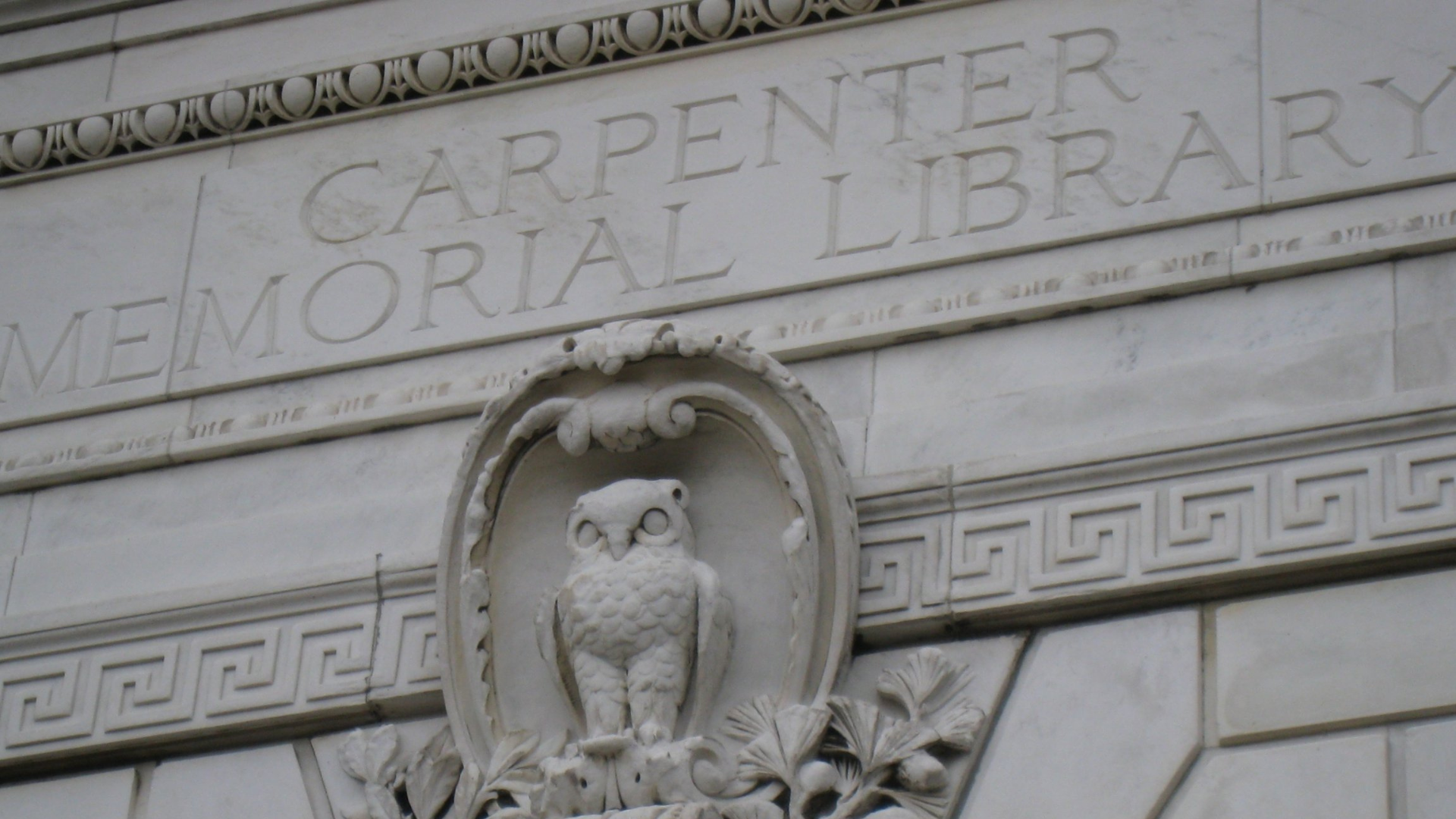 stone owl on the outside wall of a building